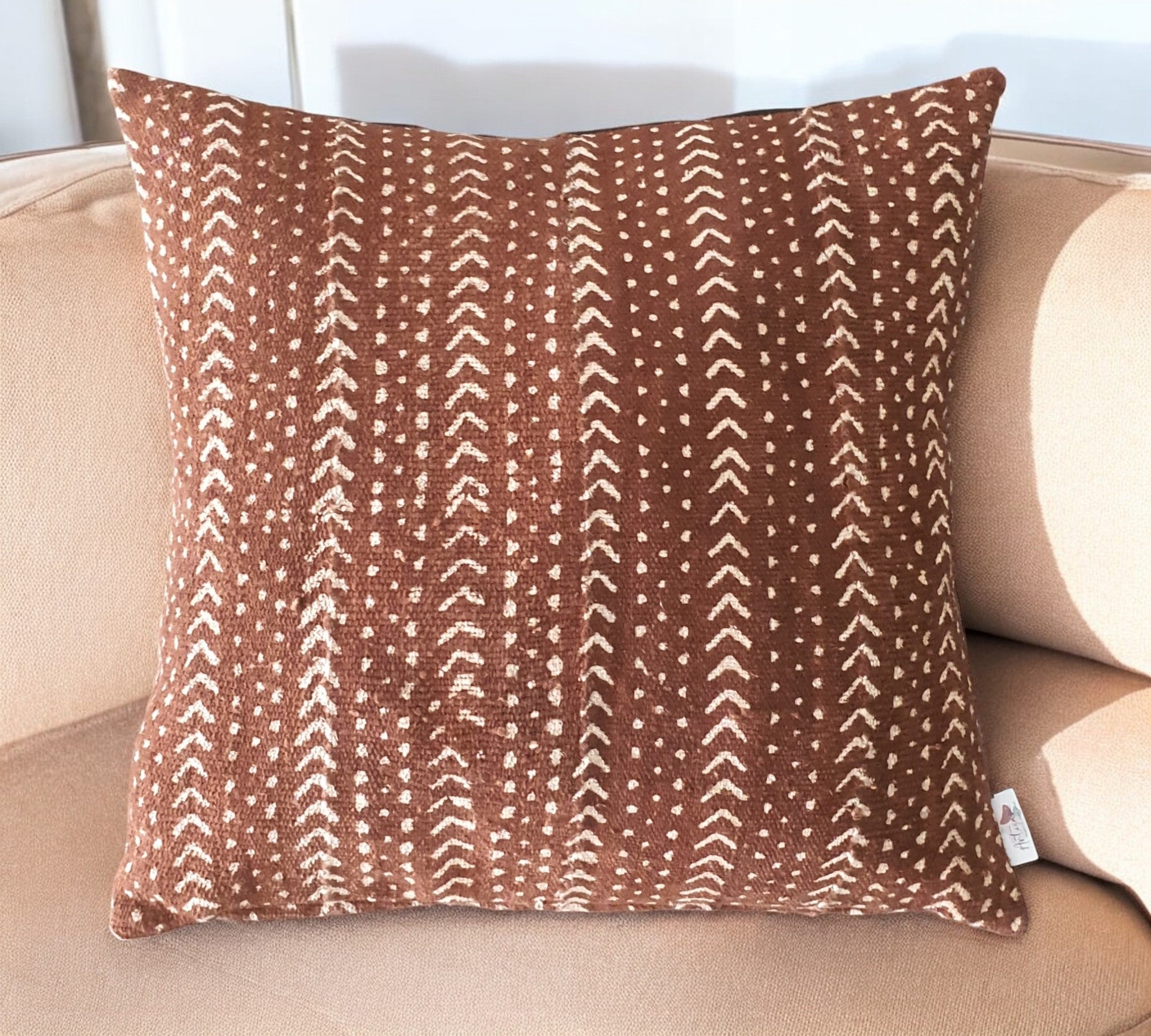 Brown pillow with a pattern on a beige couch