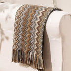 Woven blanket with zigzag pattern draped over a white sofa