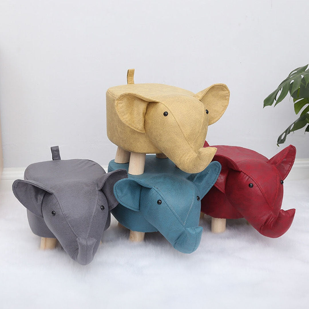 Four elephant-shaped stools in gray, blue, red, and yellow on a white background.
