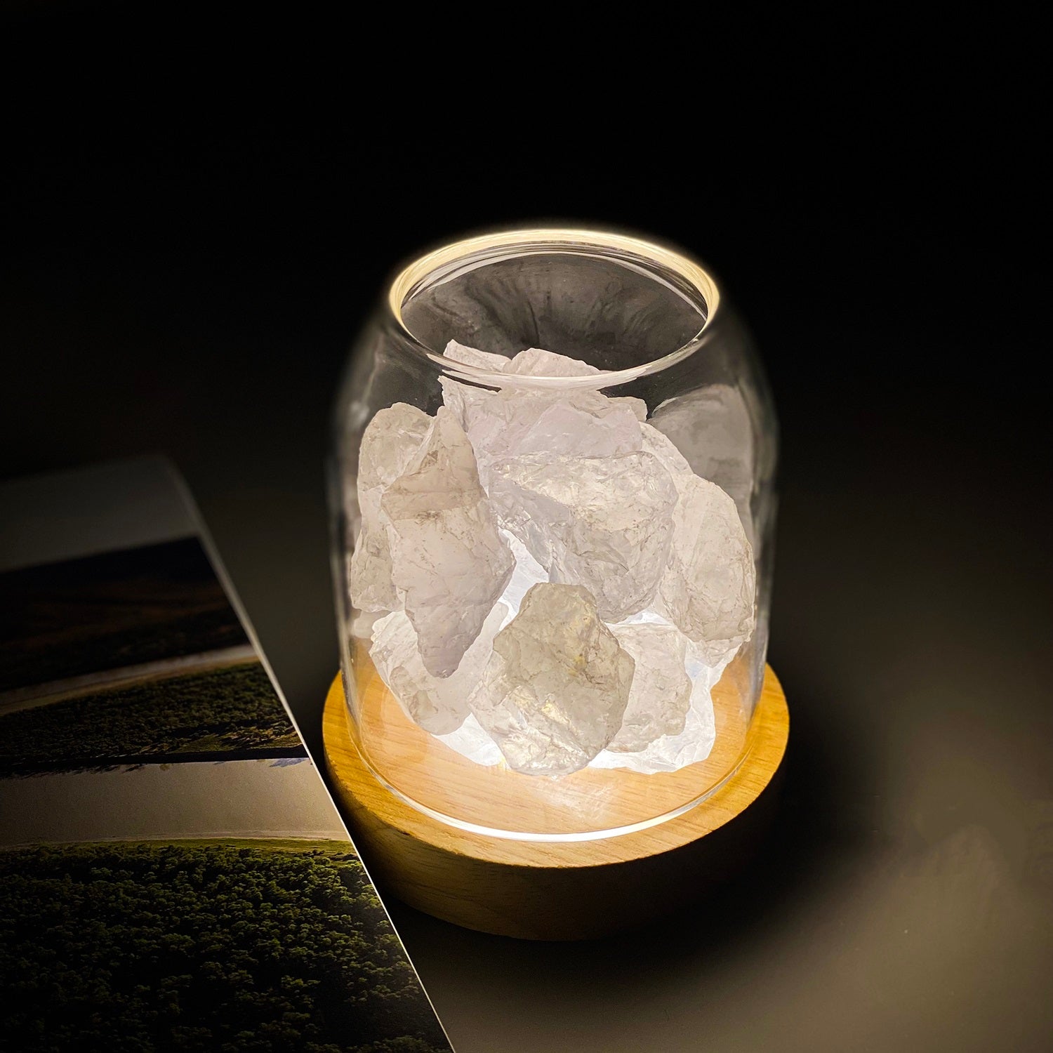 Glass jar with rocks on a wooden base against a dark background