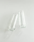 Two clear glass tumblers on a light gray background