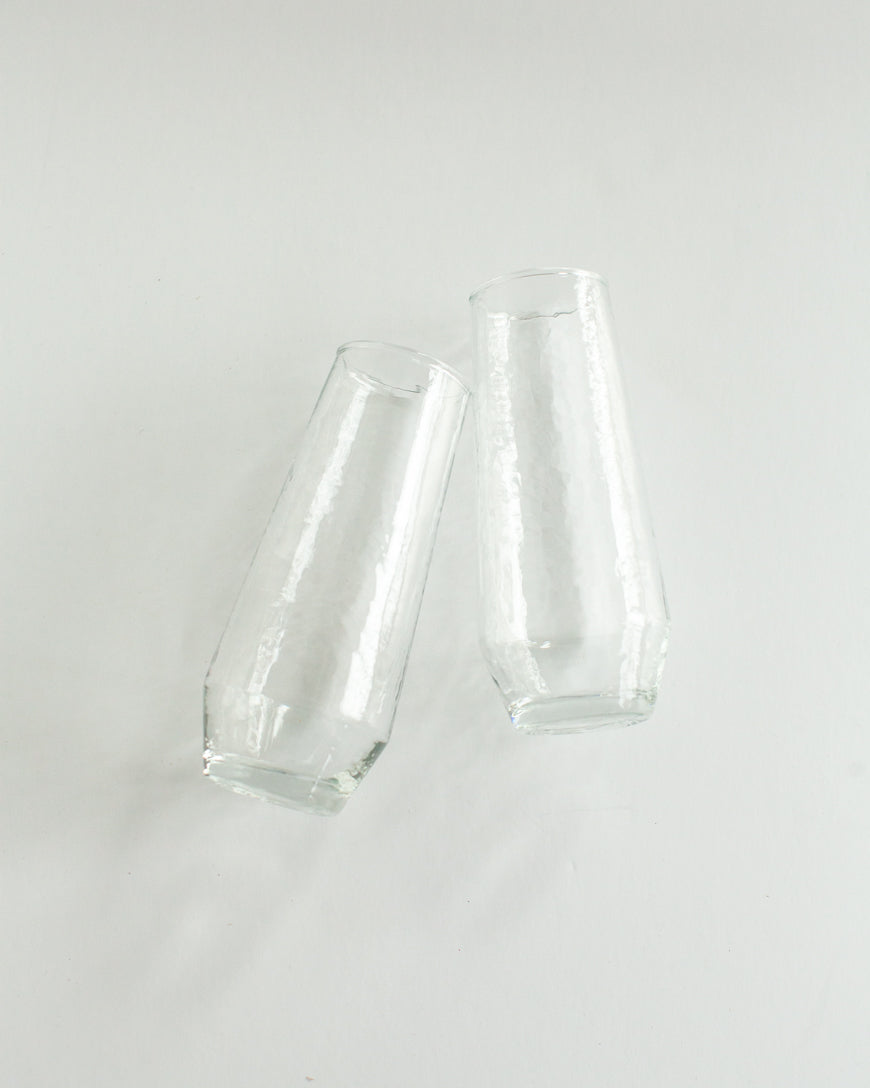 Two clear glass tumblers on a light gray background