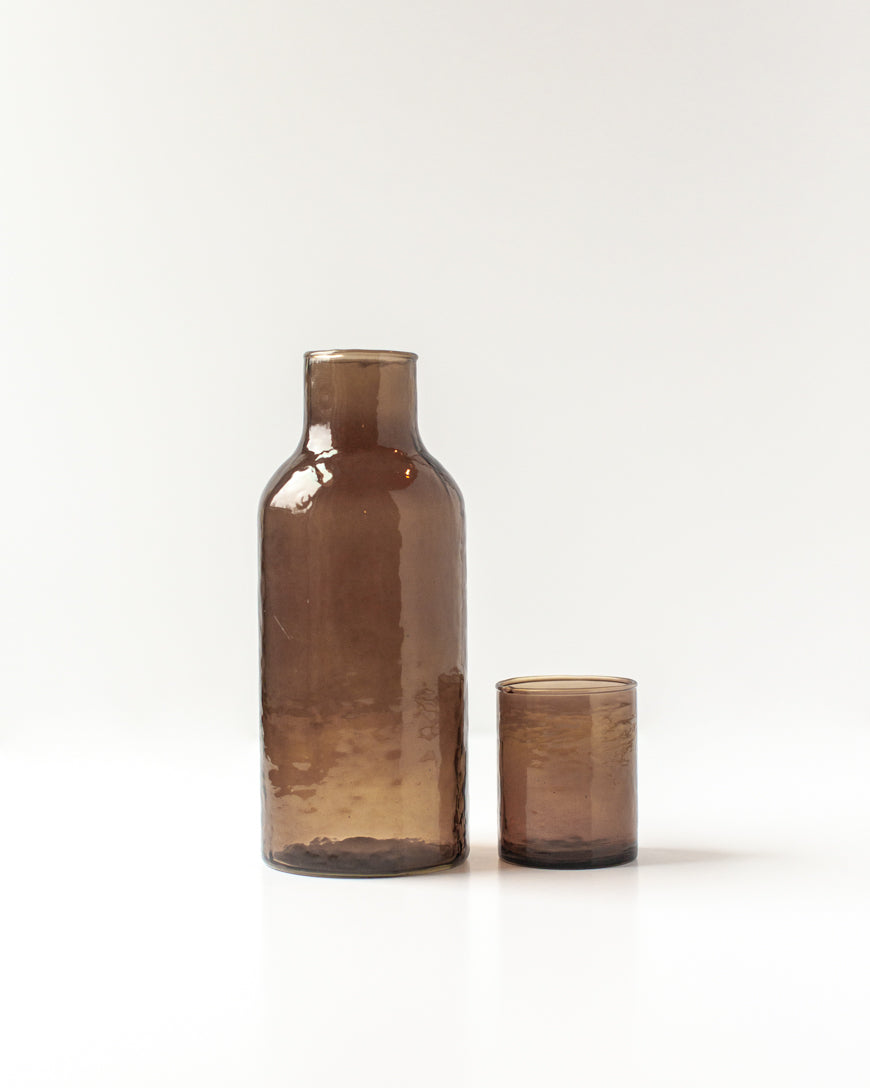 Brown glass bottle and candle on a white background