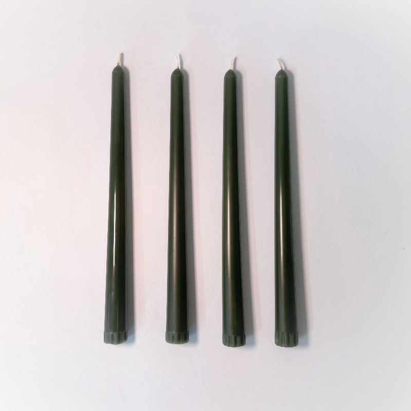 Four dark green candles on a white background