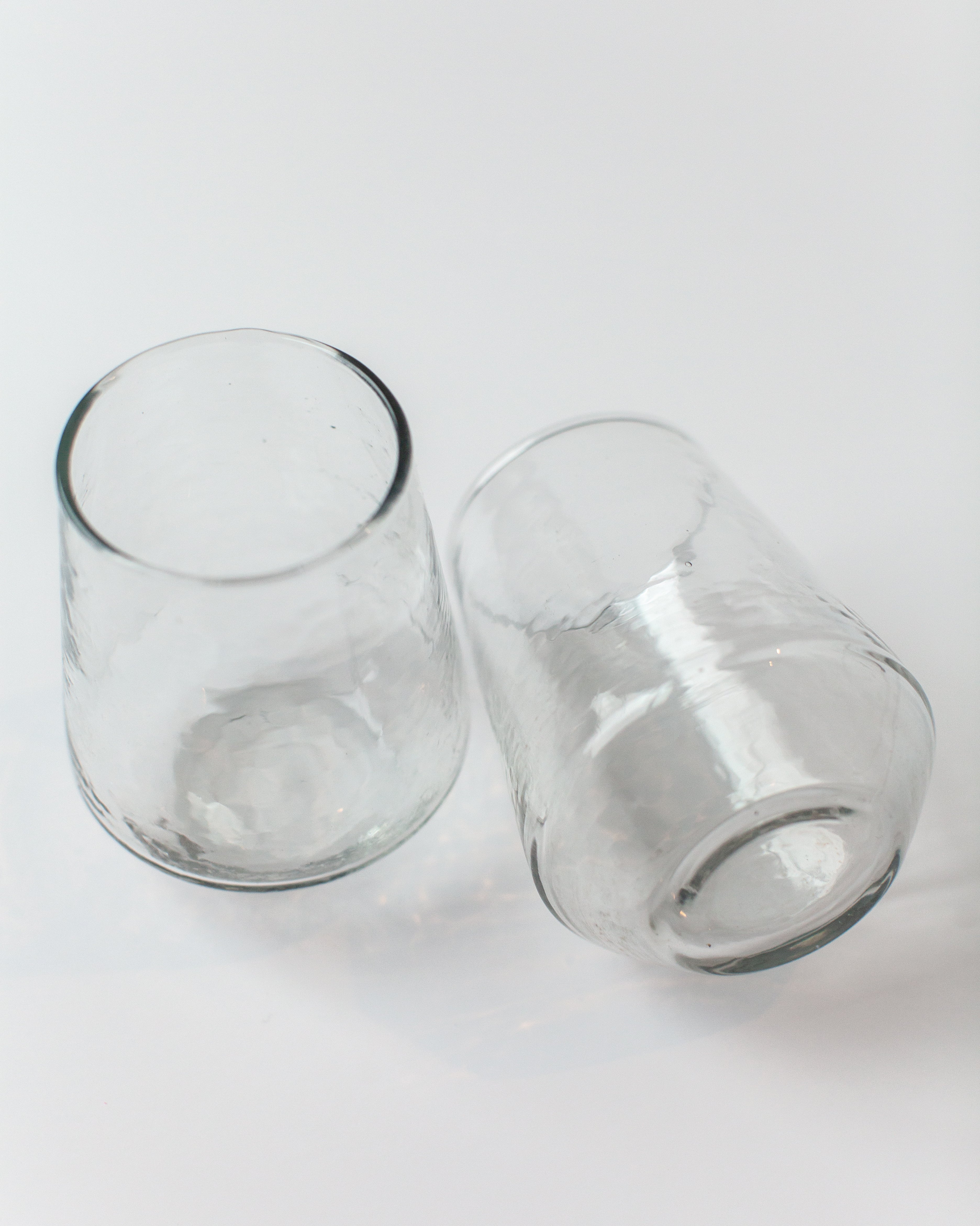 Two clear glass tumblers on a white background