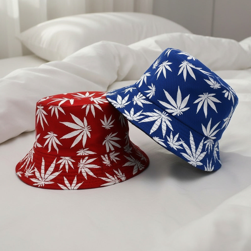 Two bucket hats, one red with white leaf pattern and one blue with white leaf pattern, on a white background.