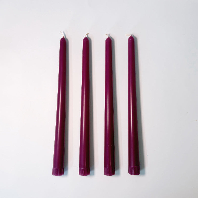 Five dark pink candles of varying heights on a white background