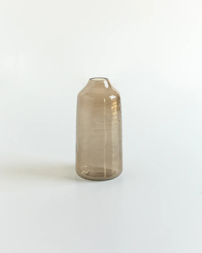 Transparent brown glass bottle on a white background