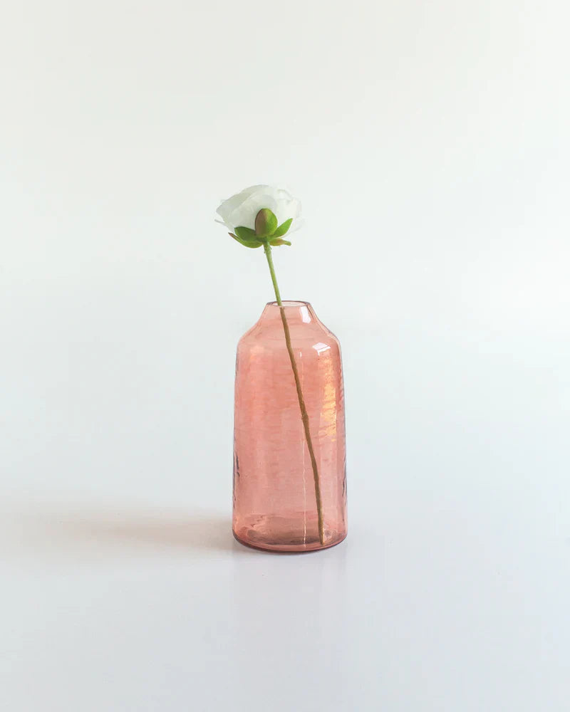 Pink vase with a white flower on a light gray background
