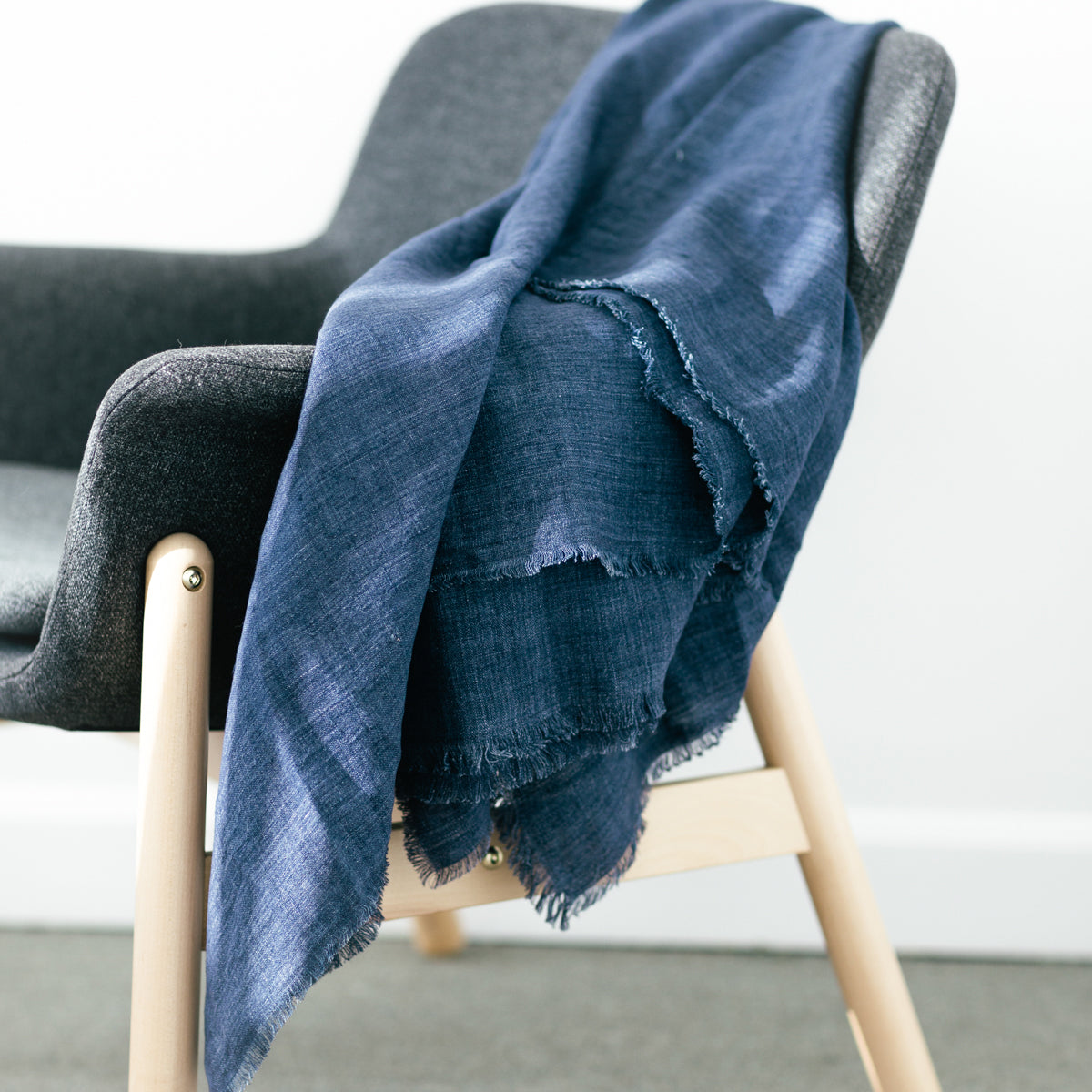 Blue blanket draped over a gray chair with a blurred background