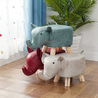 Three colorful elephant-shaped stools on a wooden floor with a plant in the background.